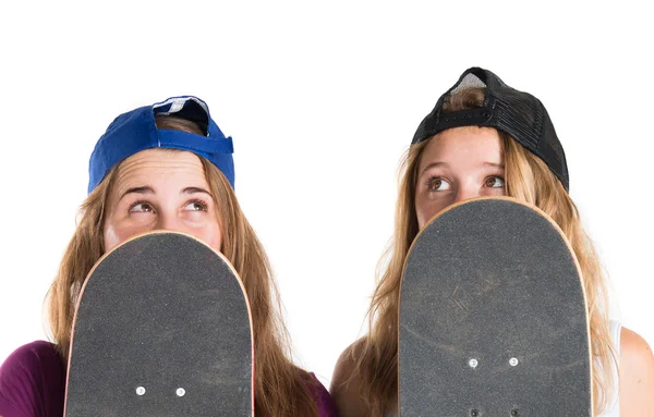 Meninas se escondendo atrás de seus skates — Fotografia de Stock