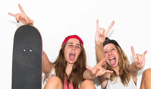 Amigos com seus skates fazendo gesto chifre — Fotografia de Stock