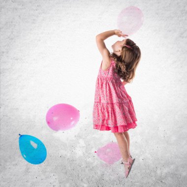 Kız balonlarla oynuyor.