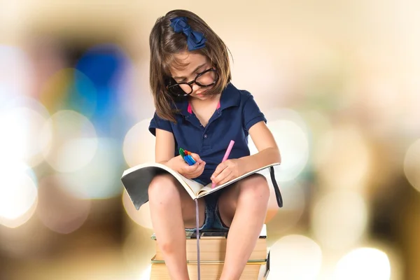 Dívka studuje na hromadě knih — Stock fotografie