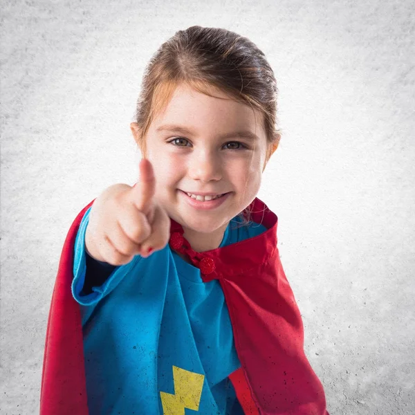 Flicka klädd som superhjälte pekar på framsidan — Stockfoto