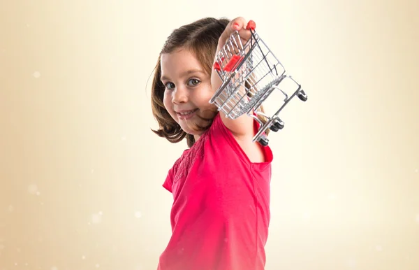 Chica jugando con mini carrito supermaeket —  Fotos de Stock