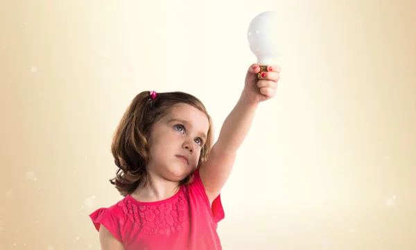 Ragazza che tiene una lampadina — Foto Stock