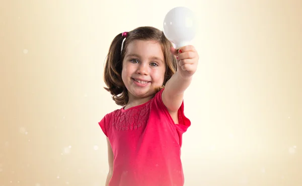 Chica sosteniendo una bombilla — Foto de Stock