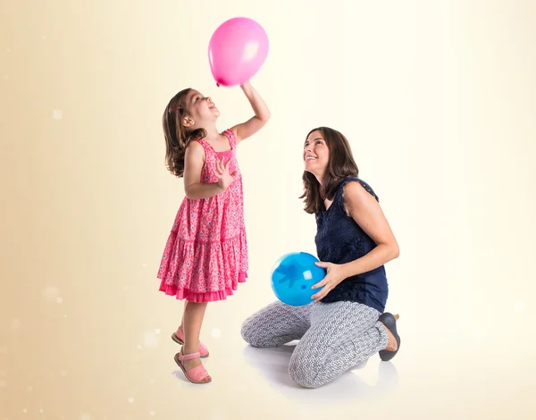 Mother and daughter playing with balloons — Stock Photo, Image