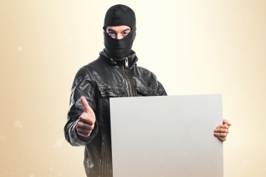 Boş bir afiş tutarak soyguncu