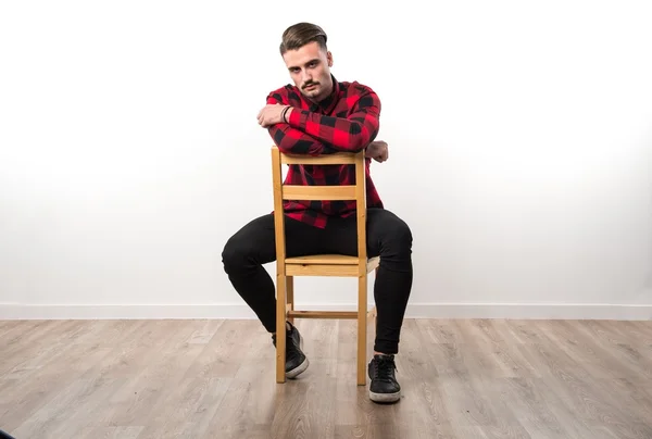 Model człowieka w studio siedzi na drewniane krzesło — Zdjęcie stockowe