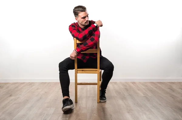 Model człowieka w studio siedzi na drewniane krzesło — Zdjęcie stockowe