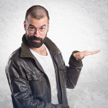 Bir şey tutan bir deri ceket giyen adam