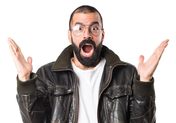 Homem usando uma jaqueta de couro fazendo gesto surpresa — Fotografia de Stock