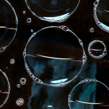 Cam yüzeyde sabun köpüğü var. Siyah arka planda izole edilmiş. Karanlıkta ışık. Soyut aydınlatma dekorasyonu. Gece kulübü soyut duvar kağıdı