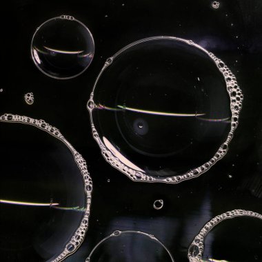 Cam yüzeyde sabun köpüğü var. Siyah arka planda izole edilmiş. Karanlıkta ışık. Soyut aydınlatma dekorasyonu. Gece kulübü soyut duvar kağıdı