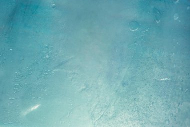 Kış mavisi soğuk soyut arka plan. Soğuk güneş ışığı görüntüsü. Bulanık zeminde soğuk bir tonda havanın neminden kaynaklanan su damlacıklarındaki şeffaf camlar. Yoğunlaşmanın dokusu mavi. 