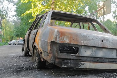 Yanmış bir araba bahçede terk edilmiş..