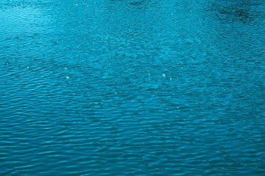 Mavi su arka planı. Denizin sakin yüzeyi. Okyanus. Doğal soyut arka plan. Film tahılları ve gürültü.