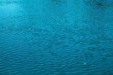 Mavi su arka planı. Denizin sakin yüzeyi. Okyanus. Doğal soyut arka plan. Film tahılları ve gürültü.