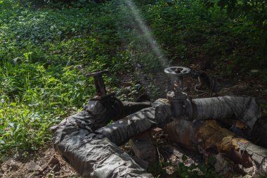 Metal kapaklı eski bir boru. Vinçli boru hattı var. Gaz boru hattı.