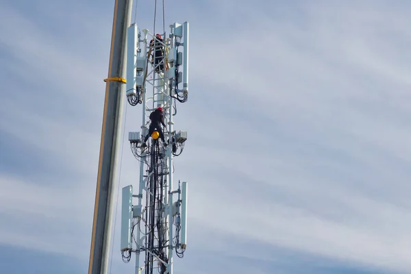 Assembly of a new 5G network telecommunications tower with two technicians in The Netherlands