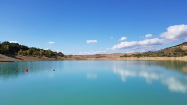 İspanya 'da temiz mavi suyu ve mavi gökyüzü olan sakin bir dağ gölü.