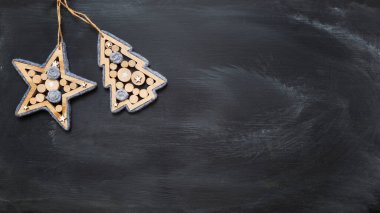 Dekoratif ahşap Noel ağacı ve kara tahta arka planda yıldız