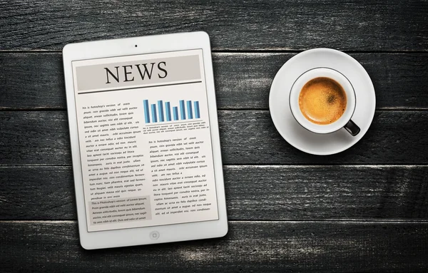 News article on digital tablet and coffee cup — Stock Photo, Image