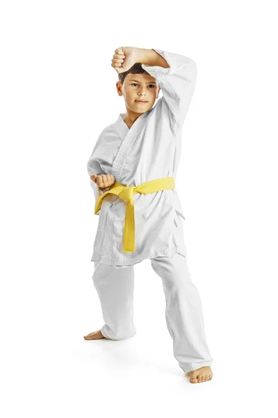 Karate çocuk egzersiz beyaz zemin üzerine tam uzunlukta portresi — Stok fotoğraf