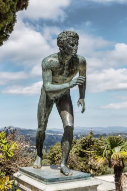 A statue of 'The Runner' in the garden of Achilleion clipart