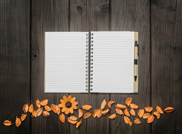 Flores y un cuaderno de bocetos en un escritorio — Foto de Stock