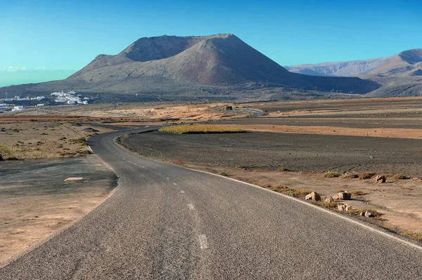 Una strada sul paesaggio vulcanico all'isola di Lanzarote, Isole Canarie — Foto Stock