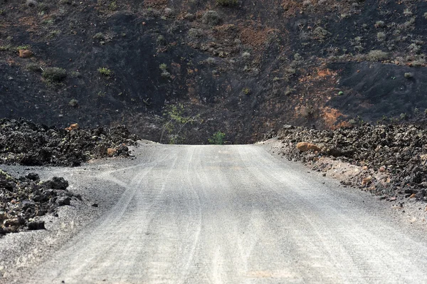 Un camino sobre el paisaje volcánico en Lanzarote Island, Canary Island —  Fotos de Stock