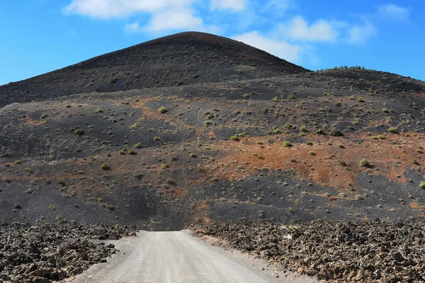 Eine straße in vulkanischer landschaft auf lanzarote, kanarische insel — Stockfoto