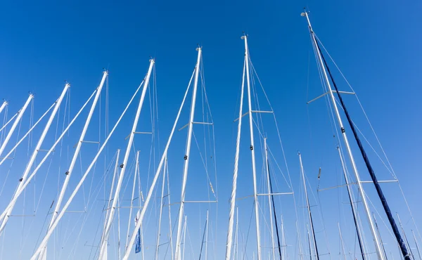 Mástil contra un cielo azul, mástil de barco, puerto deportivo en la ciudad europea, el — Foto de Stock