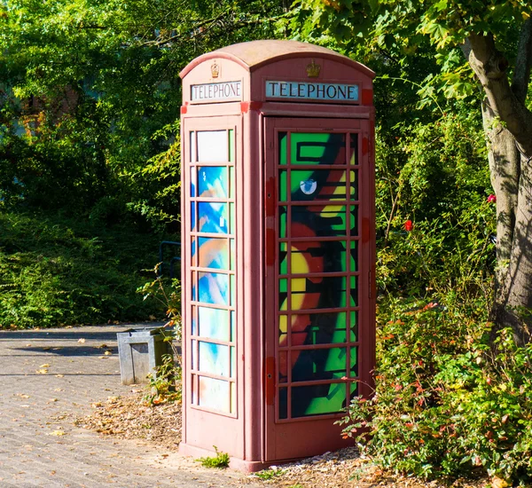 Painted old red phone booth, phone box, painted in different col — Stock Photo, Image