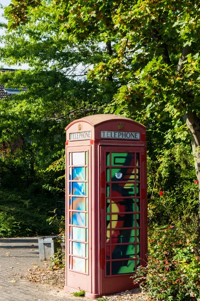 Painted old red phone booth, phone box, painted in different col — Stock Photo, Image