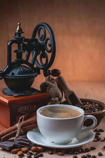 Oude koffiemolen en een kopje koffie — Stockfoto