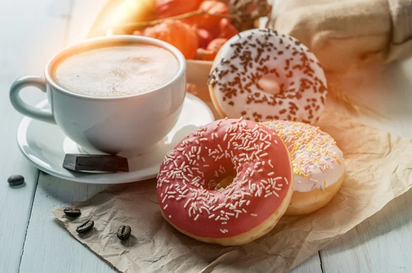 Tre donut och en kopp kaffe med choklad — Stockfoto