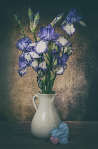 Irises in vase and hearts — Stock Photo, Image