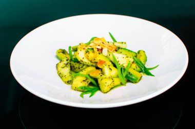 Beyaz tabakta fıstık ve tarhun soslu avokado salatası.