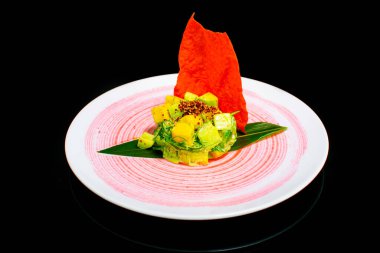 Beyaz tabakta mango, avokado, ton balığı ve susam soslu yakın plan salata.