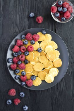 Arka planda siyah tabakta böğürtlenli mini krep manzarası.