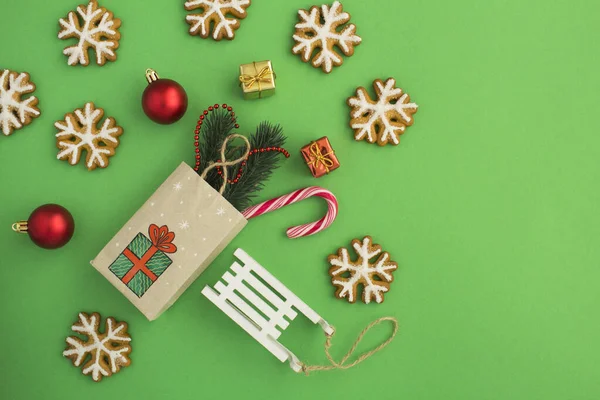 Bovenaanzicht Van Kerstcompositie Met Kadozakje Peperkoek Speelgoed Groene Achtergrond — Stockfoto