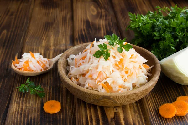 Ahşap arka plandaki kahverengi kasedeki ekşi lahanaya yaklaş.