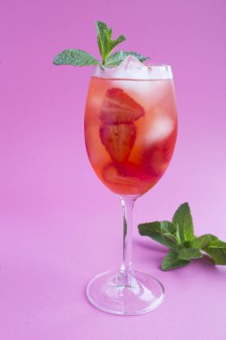 Pembe arka planda çilek ve buzlu bir bardak için.