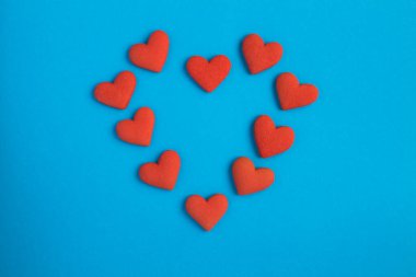 Mavi arkaplanda kırmızı kalpler şekilli kurabiyelerin üst görünümü