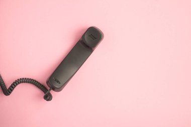 Pembe arkaplanda, kopyalama alanı olan gri telefon alıcısının üst görünümü
