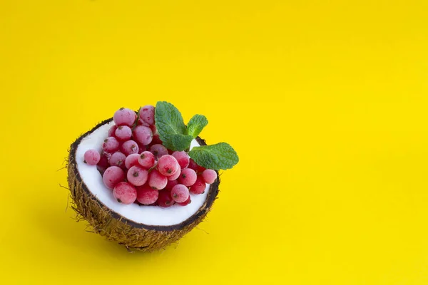 Groselhas Vermelhas Congeladas Meio Coco Fundo Amarelo Com Espaço Cópia — Fotografia de Stock