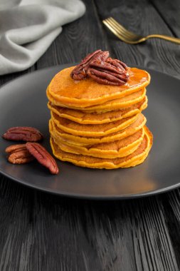 Koyu arkaplanda fındıklı ev yapımı balkabağı krepleri.