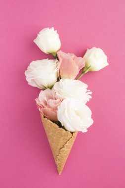 Ice cream cone with pink and white flowers on the pink background