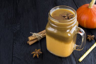 Pumpkin latte in the glass on the black background