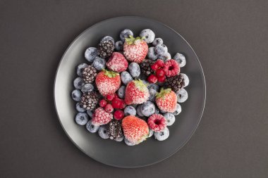 Donmuş böğürtlenlerin en üst görüntüsü, arka plandaki siyah tabakta.